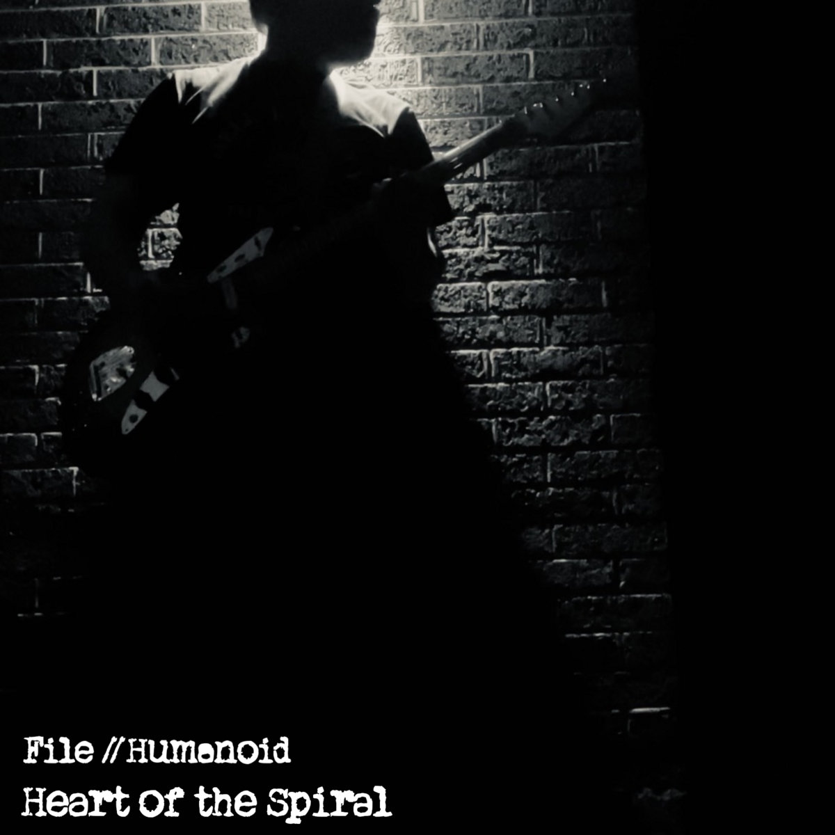 A silhouette against a brick wall, backlit, black and white.